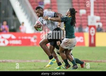 SINGAPUR-14. APRIL: Das südafrikanische 7er-Team (grün) spielt beim Cup-Finale von HSBC World Rugby Singapore Sevens am 14. April 2019 im Nationalstadion in Singapur gegen das fidschianische 7er-Team (weiß) Stockfoto