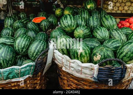 Viele große grüne Wassermelonen im Korb und ein Cut.Sweet saftige Sommer Erfrischung, Lebensmittel background.Healthy Essen voller Vitamine. Viele leckere reife Stockfoto