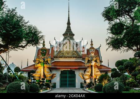 Ordination Hall neben dem buddhistischen Tempel Wat Arun in Bangkok.Thailand Wahrzeichen.Bunte Porzellanstatuen.Skulpturen von zwei mythischen riesigen Dämonen Stockfoto