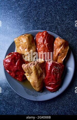 Paprika gefüllt mit Hackfleisch auf einem blauen Hintergrund aus Holz. Blick von oben. Stockfoto