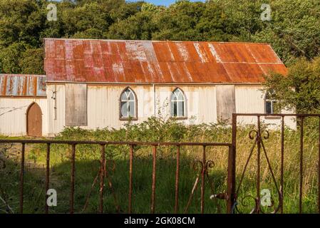 Die Kirche aus vorgefertigtem Wellblech oder Zinn, die von hellem Abendlicht in Torrisdale in einem Gebiet, das allgemein als Skerray in der Nähe der NC500 bezeichnet wird, beleuchtet wird. Stockfoto