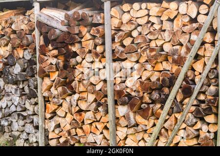 Vorbereitet für den Winter eine Mischung aus Brennholz von verschiedenen Baumarten, ordentlich in einer Speisekammer für Brennholz gestapelt. Brennholz für Raumheizung und Stockfoto