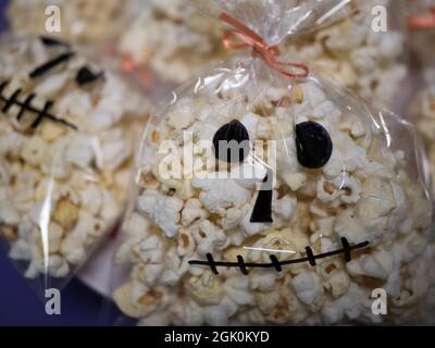 Halloween Essen, Tüte mit köstlichem Popcorn in Form von Totenkopf Stockfoto