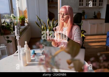 Professionelle Make-up-Künstler zeigt Pinsel Aufnahme Tutorial am Tisch mit kosmetischen Produkten Stockfoto