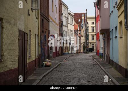 Lübeck, 11. September 2021: Boetcherstraße, eine schmale Gasse in der Nähe des Hafens mit Kopfsteinpflaster, historischen Häusern, Graffiti und Müll im O Stockfoto