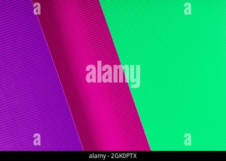 Struktur aus purpurfarbenem, pinkem und mintfarbenem Wellpapier. Geometrische Formen und Linien. Minimalistischer Hintergrund. Flach liegend. Speicherplatz kopieren. Stockfoto