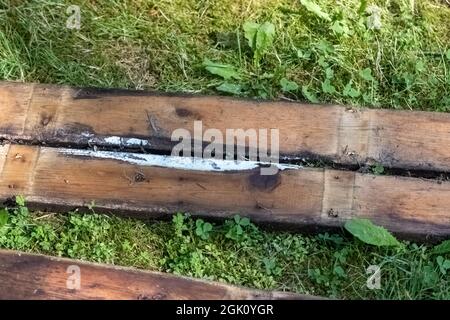 Alte Holzplanken, die nach einem Abbruchjob auf Gras liegen Stockfoto