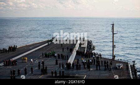 210911-N-UD000-2006 ATLANTIK (AUG 26, 2021) Seeleute an Bord des Flugzeugträgers USS George H.W. Bush (CVN 77) trifft sich auf dem Flugdeck, um zu beobachten, wie eine Vermisste-Formation zum Gedenken an diejenigen überfliegt, die vor 20 Jahren während der Terroranschläge vom 11. September 2001 ihr Leben verloren haben. GHWB ist im Atlantischen Ozean tätig, um Marinestützungen zu unterstützen, um die maritime Stabilität und Sicherheit zu erhalten, um den Zugang zu gewährleisten, Aggressionen abzuwehren und die Interessen der USA, der Alliierten und der Partner zu verteidigen. (USA Navy Foto von Mass Communication Specialist 3rd Class Bryan Valek) Stockfoto