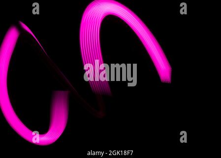 Schöne rosa Linien auf schwarzem Hintergrund mit Platz für Text. Stockfoto