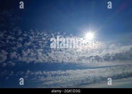 Die Strahlen der Sonne scheinen in fantastischen Wolken. Sonnentag-Konzept, mit Kopierplatz Stockfoto