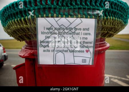 Lytham Geen, Lytham, Lancashire, Großbritannien. September 2021. Eine Häkelwindmühle erschien als Krone auf einer benachbarten Säulenbox mit der Legende „Ich wurde mit Liebe und Freundlichkeit hergestellt, um zu zeigen, dass ich mich kümmere. Bitte seid nett zu mir, denn mein Vater ist da! Teile mein Bild auf FB oder Random Acts of Crochet Freundlichkeit Credit: PN News/Alamy Live News Stockfoto