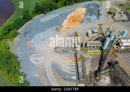 Luftaufnahme des Panorama-Steinbruchs im Tagebau mit vielen Maschinen an Arbeitsgeräten in einer Anlage Stockfoto