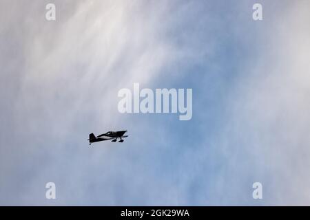 Doppeldecker, die hoch oben am Himmel flogen, schilhouetteten vor einem Sonnenuntergang Stockfoto