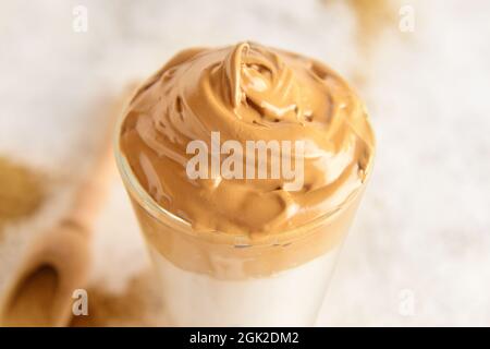 Ein Glas leckeren dalgona hojicha Latte auf hellem Hintergrund, Nahaufnahme Stockfoto