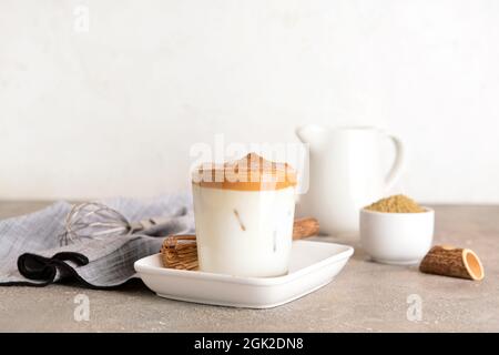 Ein Glas schmackhafter dalgona hojicha und Chasen auf dem Tisch Stockfoto