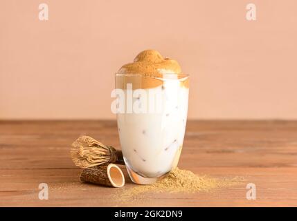 Ein Glas schmackhafter dalgona hojicha, Chasen und Pulver auf dem Tisch Stockfoto