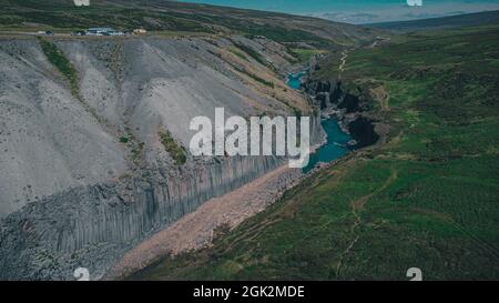 Luftdrohnenpanorama der studlagil Schlucht in Island, malerisches Tal mit Basaltsäulen, die an einem warmen Sommertag hoch stehen. Stockfoto