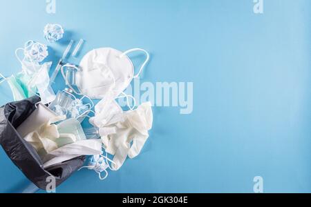 Covid-19 Plastikmüll und -Abfall, Einwegmasken, Medizinhandschuh, Alkoholgelflasche und Nadel im Abfalleimer. Stapel von gebrauchten persönlichen Schutzausrüstungen Stockfoto