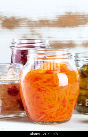 Ein Glas eingelegter Karotte mit anderen fermentierten Lebensmitteln im Hintergrund. Gemüse einkochen, hausgemachte Konfitüren Konzept mit einem Platz für Text Stockfoto