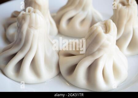 Gekochte khinkali oder kaukasische Knödel auf der keramischen Platte, die Nahaufnahme der gekochten khinkali mit dem Dampf Stockfoto
