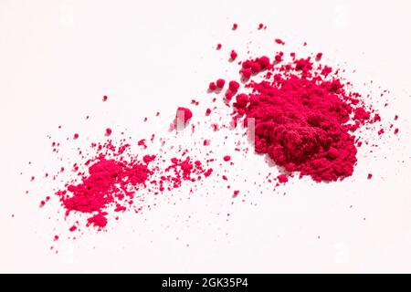 Nahaufnahme eines Teils des roten Pigments, der in der Seitenansicht auf Weiß isoliert ist. Das Pigment wird mit Leinöl gemischt, um Ölfarbe zu erhalten Stockfoto