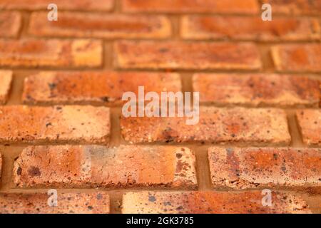 Nahaufnahme der Wand aus roten Ziegeln mit schwarzen Einschlüssen Background Ziegel mit Textur Stockfoto