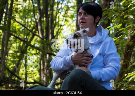 Junge Frau mit Jack Russel Terrier im Wald Stockfoto