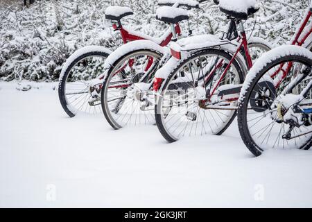 Fahrräder bedeckt mit Neuschnee in einer Stadt, Winter Schneezeit Stockfoto