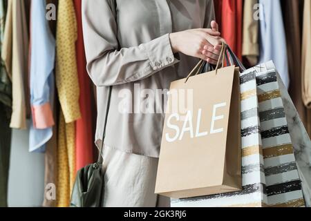Nahaufnahme einer jungen Frau, die Einkaufstaschen in der Hand hält, während sie im Einkaufszentrum Einkäufe tätigt Stockfoto