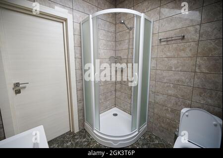 Badezimmer mit Duschkabine und Toilette im modernen braunen Interieur Stockfoto