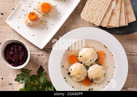 Traditionelle jüdische Matzah-Kugelsuppe, gefilter Fisch und Matzah-Brot auf Holztisch Stockfoto