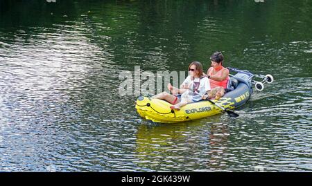 Zwei Frauen im aufblasbaren Kajak paddeln auf dem Fluss. Stockfoto