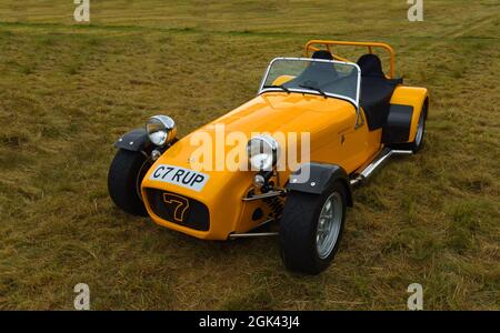 Iconic Yellow Caterham C7 Car isoliert auf Gras. Stockfoto