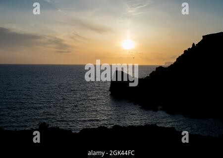 Sonnenuntergang an einem schönen Frühlingstag mit ruhigem Meer, von Anchor Bay, Mellieha, Malta aus gesehen. Stockfoto