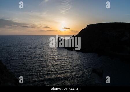 Sonnenuntergang an einem schönen Frühlingstag mit ruhigem Meer, von Anchor Bay, Mellieha, Malta aus gesehen. Stockfoto