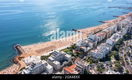 Schöne Luftbilder der portugiesischen Touristenstadt Quarteira. An der Küste während der Strandsaison mit Touristen, die sich sonnen. Stockfoto