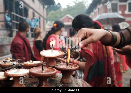 Eine Frau, die anlässlich des Teej in Pashupatinath Räucherstäbchen verbrennt Stockfoto