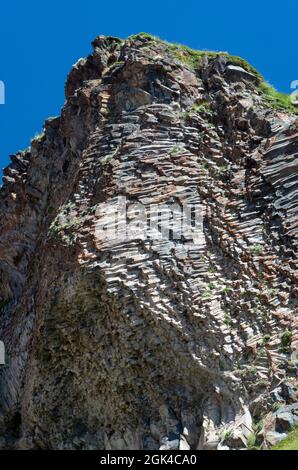 Eine steile Klippe aus graubraunem Sand mit Löchern von Schwalbennestern.in der Schlucht gibt es viele Schwalbennester in Form von Höhlen und Gruben Stockfoto