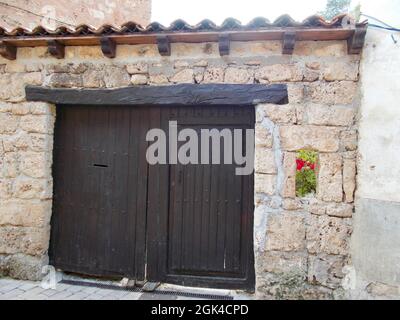 Holztür in Orbaneja del Castillo, in Burgos, in der autonomen Gemeinschaft Castilla y León, in Spanien. Europa. Horizontale Fotografie. Stockfoto