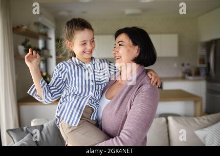 Happy kleines Mädchen mit älteren Großmutter drinnen zu Hause Spaß haben. Stockfoto