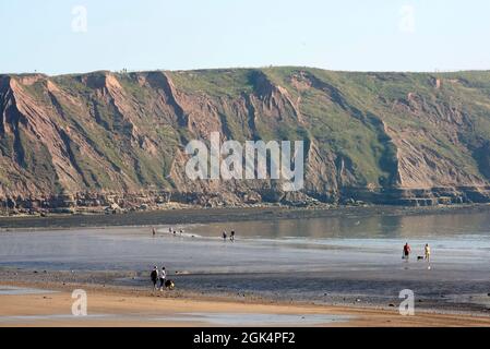 Die Klippen von Filey Brigg, Filey Beach, North Yorkshire Ostküste, beschäftigt mit Urlaubern, Nordengland, Großbritannien Stockfoto