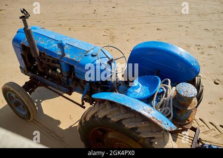 Alter Traktor, der zum Abschuss von Fischerbooten verwendet wurde, Filey Beach, North Yorkshire East Coast, beschäftigt mit Urlaubern, Nordengland, Großbritannien Stockfoto