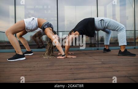 Junges Paar macht Bridge-Workout im Freien auf der Terrasse, Sport und gesundes Lifestyle-Konzept. Stockfoto