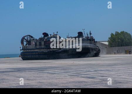 210801-M-JM820-1038 MARINESTÜTZPUNKT MOHAMMED AL-AHMAD, Kuwait (1. August 2021) Ein Landungsschiff, ein Luftkissen transportiert Marines und Ausrüstung, die der 24. Marine Expeditionary Unit (MEU) auf dem Marinestützpunkt Mohammed Al-Ahmad, Kuwait, zugewiesen wurden, 1. August. Die 24. MEU wird im Einsatzgebiet der 5. US-Flotte eingesetzt, um Marineinteraktionen zu unterstützen, um die maritime Stabilität und Sicherheit in der Zentralregion zu gewährleisten und das Mittelmeer und den Pazifik durch den westlichen Indischen Ozean und drei strategische Engpässe zu verbinden. Stockfoto