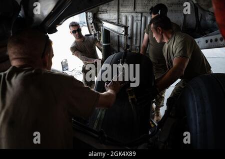 Die der 911. Wartungsgruppe zugeordneten Flieger wechseln einen Fahrwerkreifen an einem C-17 Globemaster III an der Pittsburgh International Airport Air Reserve Station, Pennsylvania, 2. August 2021. Die Piloten verwenden einen speziellen Gurt, um das Gewicht des Rades beim Entfernen aus dem Flugzeug zu unterstützen. Stockfoto