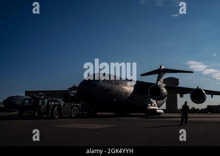 Der 911. Instandhaltungsgruppe zugewiesene Flieger bereiten den Abschleppen eines C-17 Globemaster III an der Pittsburgh International Airport Air Reserve Station, Pennsylvania, 3. August 2021 vor. Es braucht ein Team von Betreuern, um ein Flugzeug auf der Fluglinie zu schleppen, um sicherzustellen, dass das Flugzeug während des Prozesses nicht beschädigt wird. Stockfoto