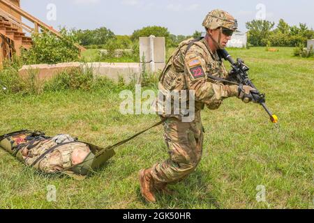 SPC der US-Armee. Todd Schaffer Jr., ein Soldat, der dem National Training Center zugewiesen wurde, schleppt eine TC3X-Schaufensterpuppe auf einer taktischen SKED-Trage während des medizinischen Streifenteils der US Army Forces Command Best Warrior Competition am 3. August 2021 in Fort Riley, Kansas. Der Wettbewerb „Beste Krieger“ besteht aus 25 Soldaten in FORSCOM, die um die Möglichkeit kämpfen, den Titel eines nicht beauftragten Offiziers und Soldaten des Jahres von FORSCOM zu erhalten, sowie die Chance, FORSCOM im Wettbewerb „Beste Krieger“ auf Armeeebene zu vertreten. Stockfoto