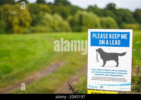 Höfliche Polizeinotiz, Schild an Hundewanderer: „Bitte führe mich an der Leine“ in ländlicher Umgebung in Großbritannien. Stockfoto