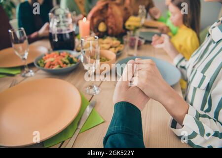 Cropped View Portrait of adorable Dreamy family Holding hands betend appreciating Lunch at Home indoor Stockfoto