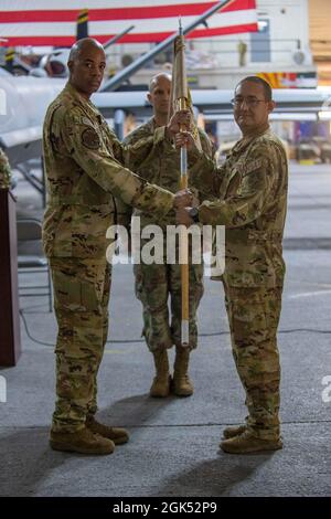 US Air Force LT. Col. Joseph Clancy (rechts), ankommender 41. Expeditionary Electronic Combat Squadron Commander, erhält die Führung von LT. Col. Brian L. Hardeman, 380. Expeditionary Maintenance Group Stellvertretender Kommandant, während der EECS-Befehlswechsel-Zeremonie auf dem Luftwaffenstützpunkt Al Dhafra, Vereinigte Arabische Emirate, 3. August 2021. Die Übergabe der Führung symbolisiert eine Übergabe des Kommandos der 41. EECS von Maj. David T. Brown an Clancy. Stockfoto